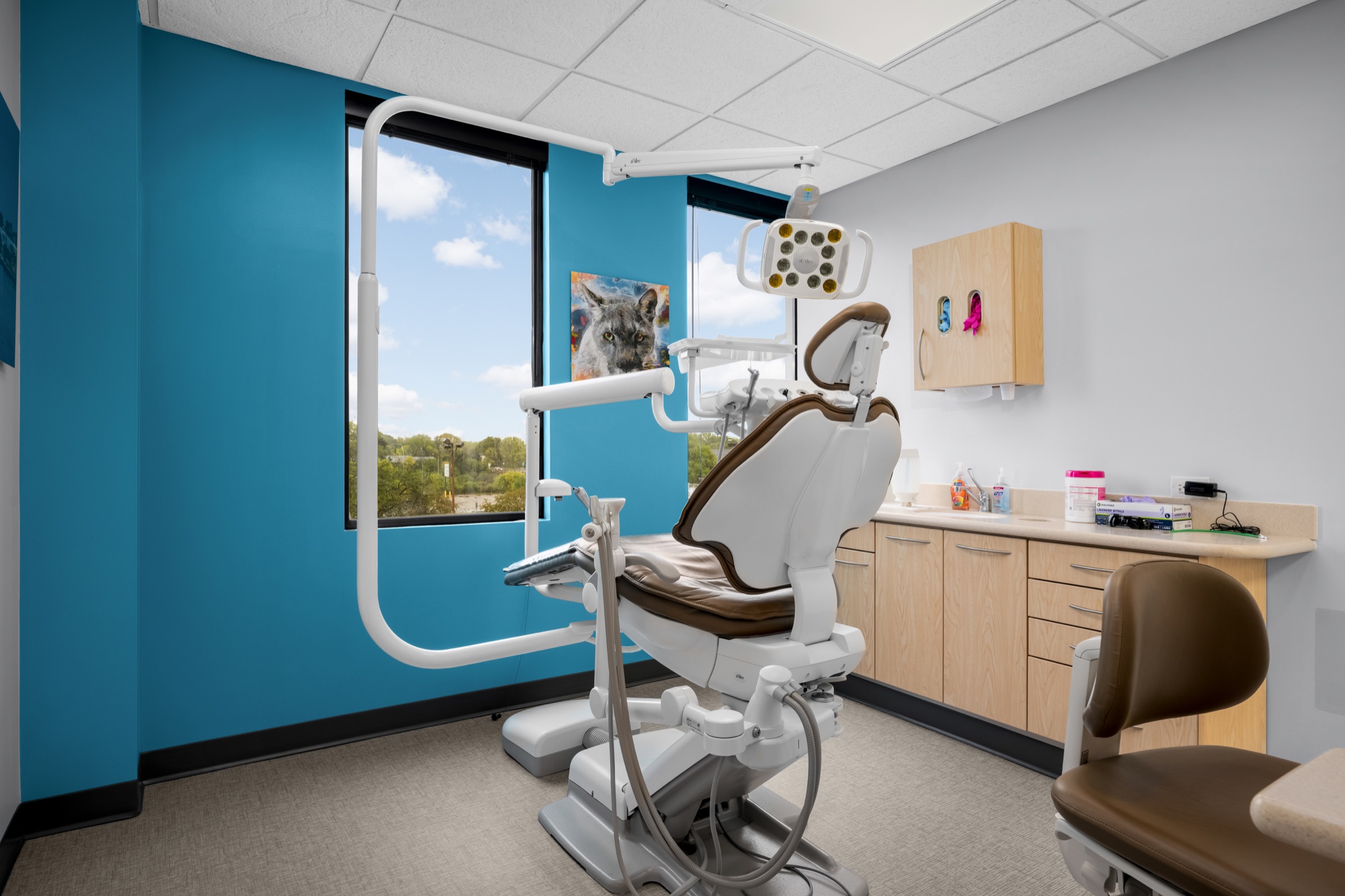 Dental treatment room with a patient chair and large windows